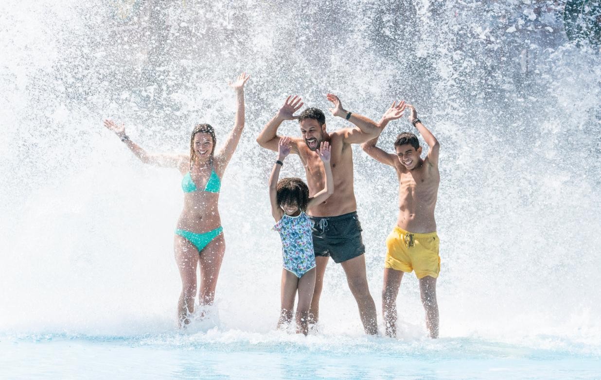 Familie in Badekleidung im Außenbecken der Wasserwelt Rulantica