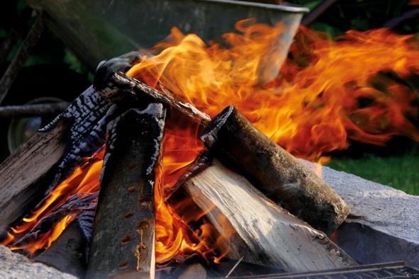 Holzscheite zu einem brennenden Lagerfeuer aufgetürmt