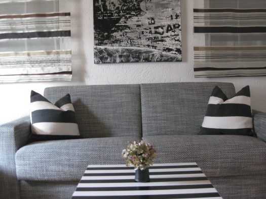graues Sofa mit schwarz-weißen Kissen und Dekoration