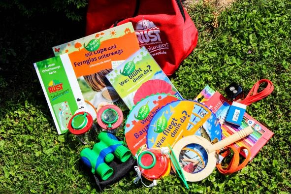 Entdeckerrucksack Entdeckerrucksack mit verschiedenen Dingen, die zum Inhalt gehören, bsp. eine Fernglas, eine Holzlupe, Bücher, eine Wanderkarte, Radierer, Becherlupen etc.